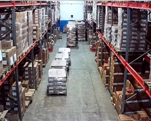 Камера расположена по центру, между стеллажами на складе